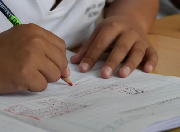Child solving a math problem in a notebook.